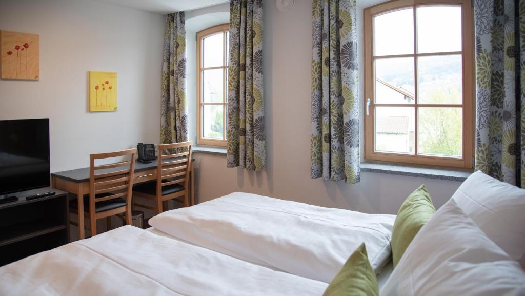 een slaapkamer met 2 bedden, een bureau en een raam bij Gasthof zur Post in Lalling