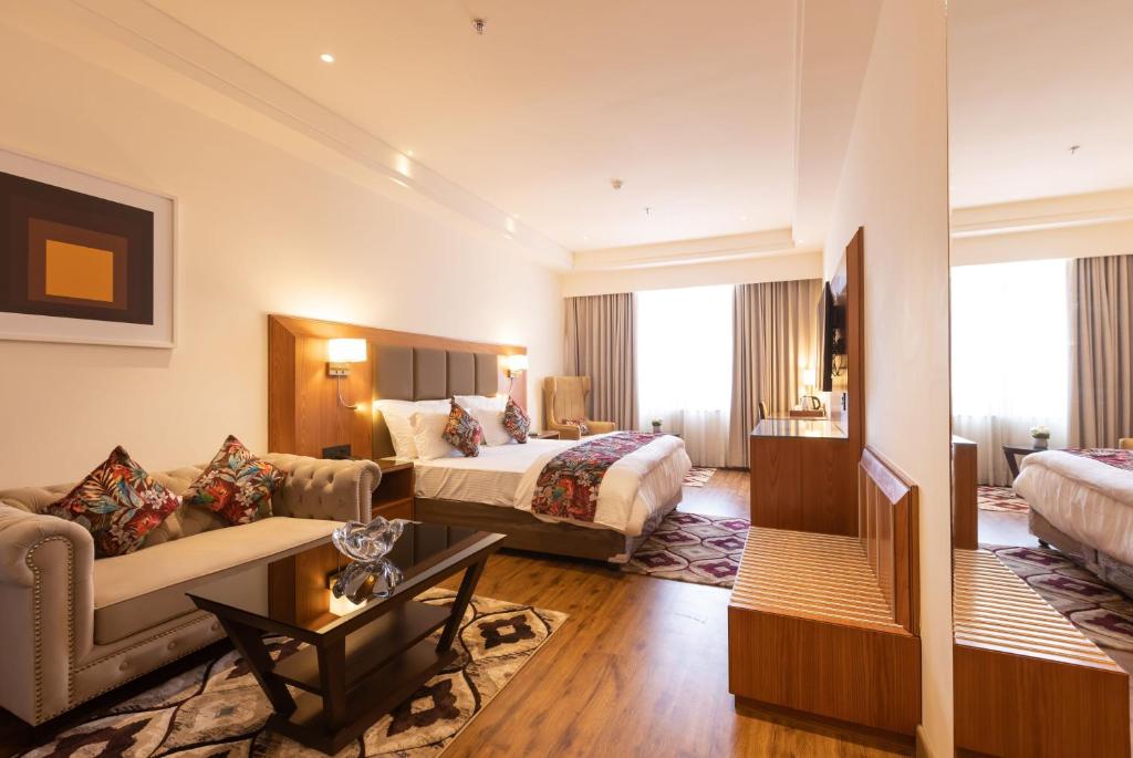 a hotel room with a bed and a couch at Clarks Inn Express Ludhiana in Ludhiana