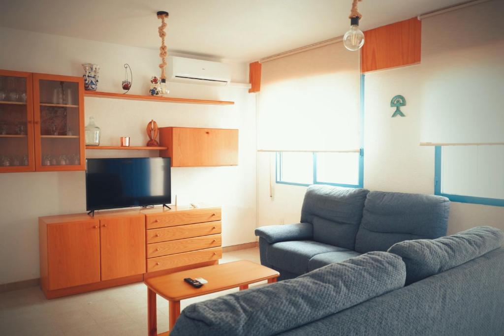 een woonkamer met een bank en een flatscreen-tv bij Casa Iqui in San José