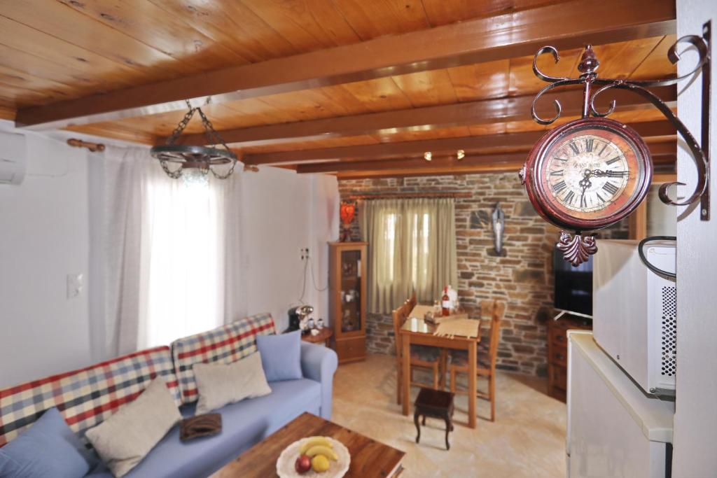 斯科派洛斯的住宿－Traditional City Centre House，客厅配有沙发和墙上的时钟