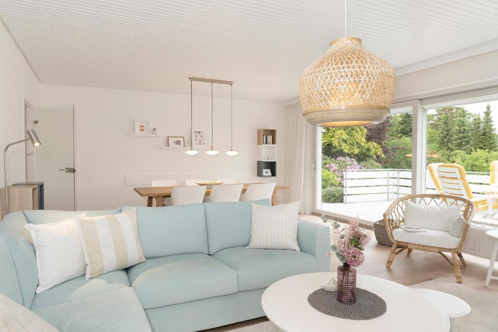 uma sala de estar com um sofá azul e uma mesa em AussichtsReich em Eutin