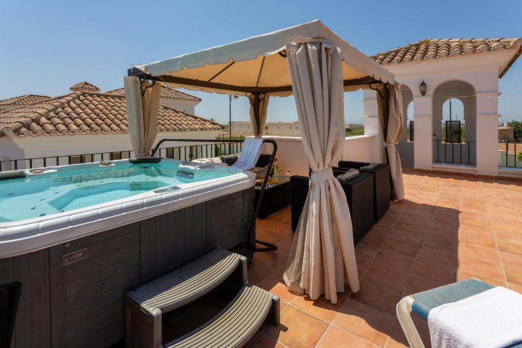 einen Whirlpool auf der Terrasse eines Hauses in der Unterkunft Luxury Spa and golf villa Denton in Las Armeras