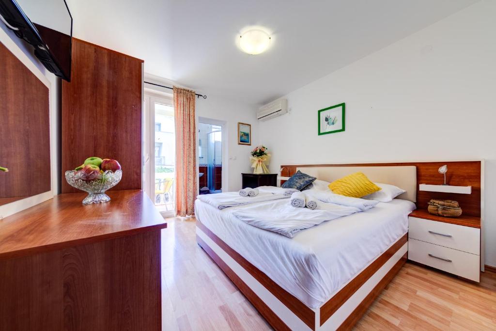 a bedroom with a bed with a bowl of fruit on it at Porta Volta Apartments in Becici