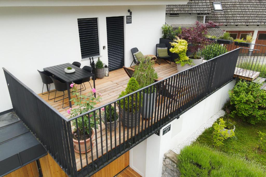 a balcony with a table and potted plants on it at House 24 Bled in Bled