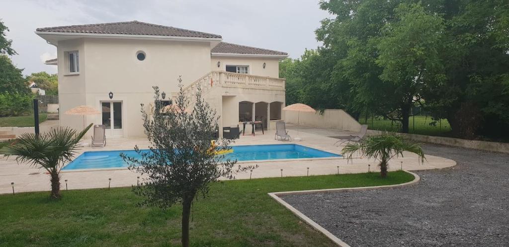 uma grande casa branca com piscina em maison calme et spacieuse em Bassens