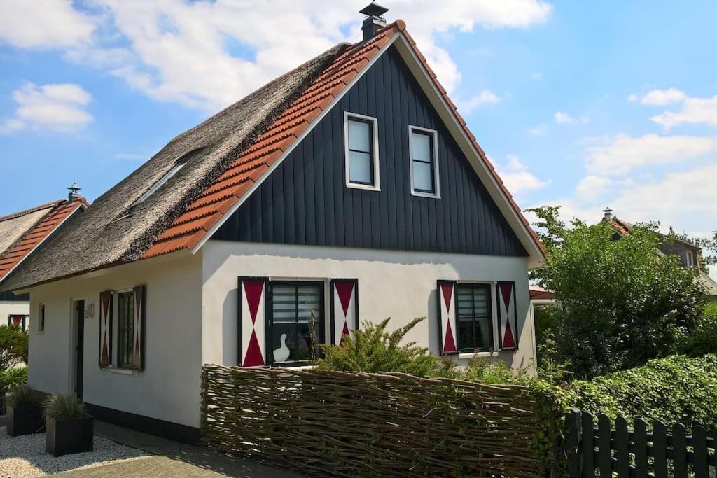 una pequeña casa con techo negro en Buitenplaats 62 Callantsoog, en Callantsoog