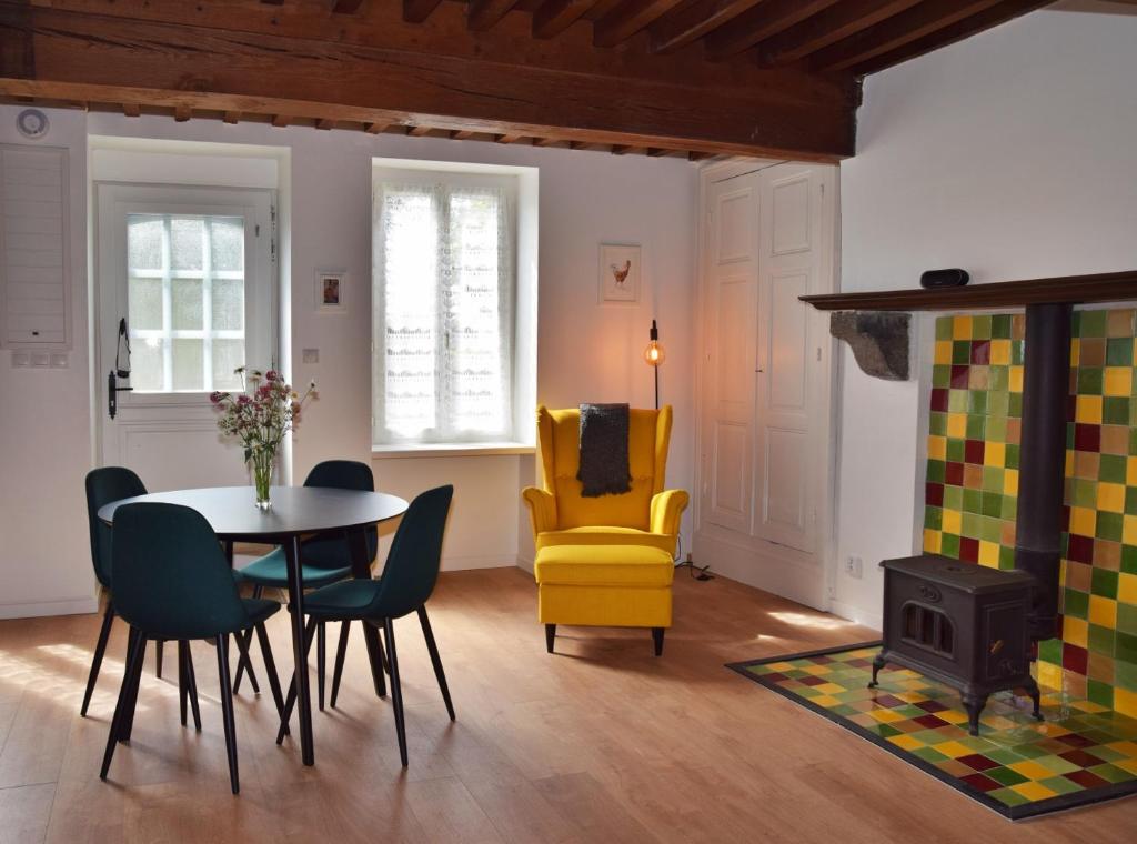 sala de estar con mesa y silla amarilla en Chez Daniel, en Vauclaix
