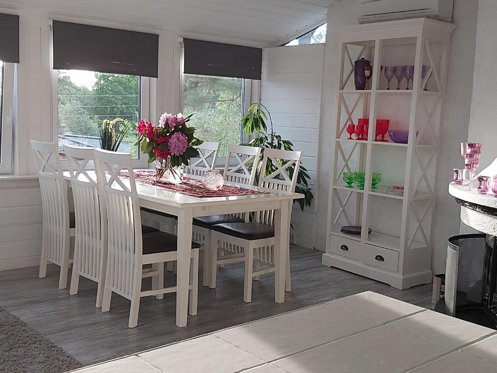 a dining room with a white table and chairs at Solstua in Sandefjord