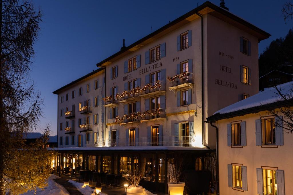 a large white building with a balcony in the snow at Hôtel Bella Tola & SPA in Saint-Luc