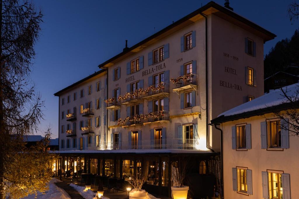 ein großes weißes Gebäude mit Balkon im Schnee in der Unterkunft Hôtel Bella Tola & SPA in Saint-Luc