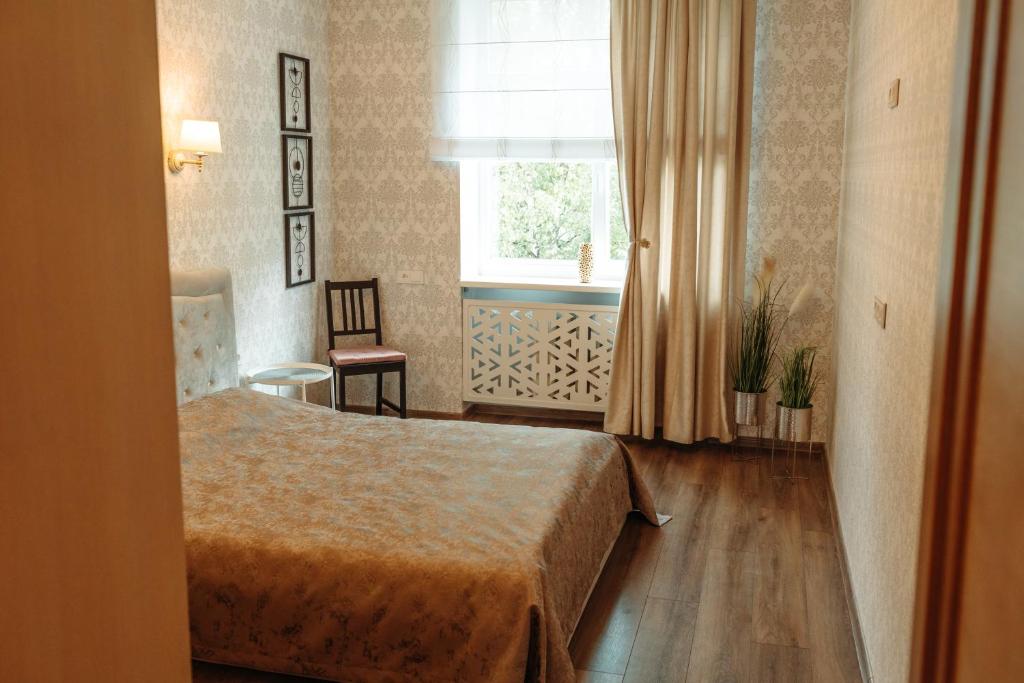 um quarto de hotel com uma cama e uma janela em 2 bedroom central flat em Jelgava