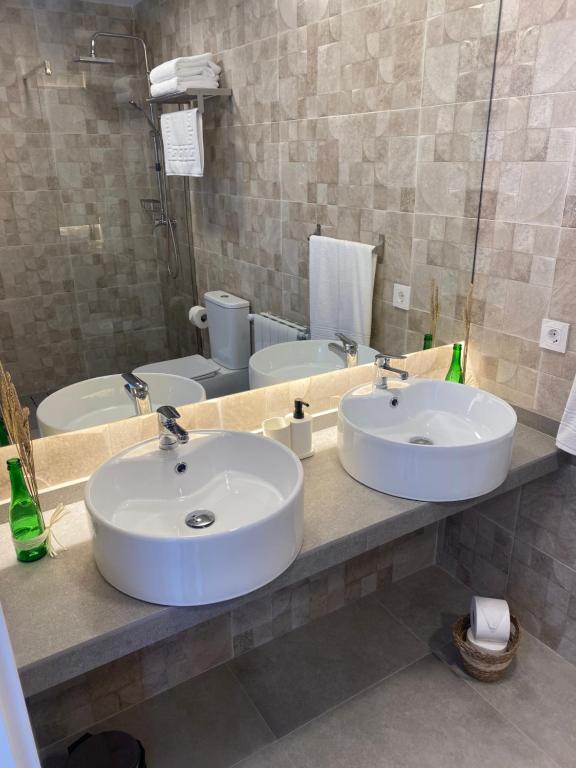 a bathroom with two sinks and two toilets at Alojamiento El Miajon de los Castúos in Valdesalor