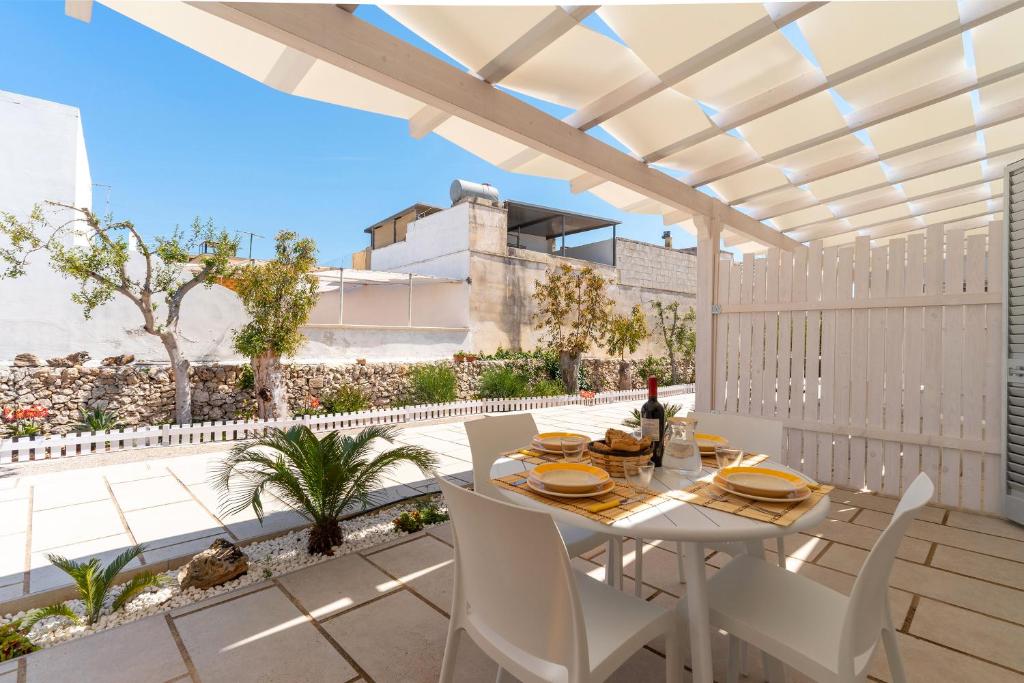 un patio con tavolo e sedie sul balcone. di Residence Jolly Mare by BarbarHouse a Torre Lapillo