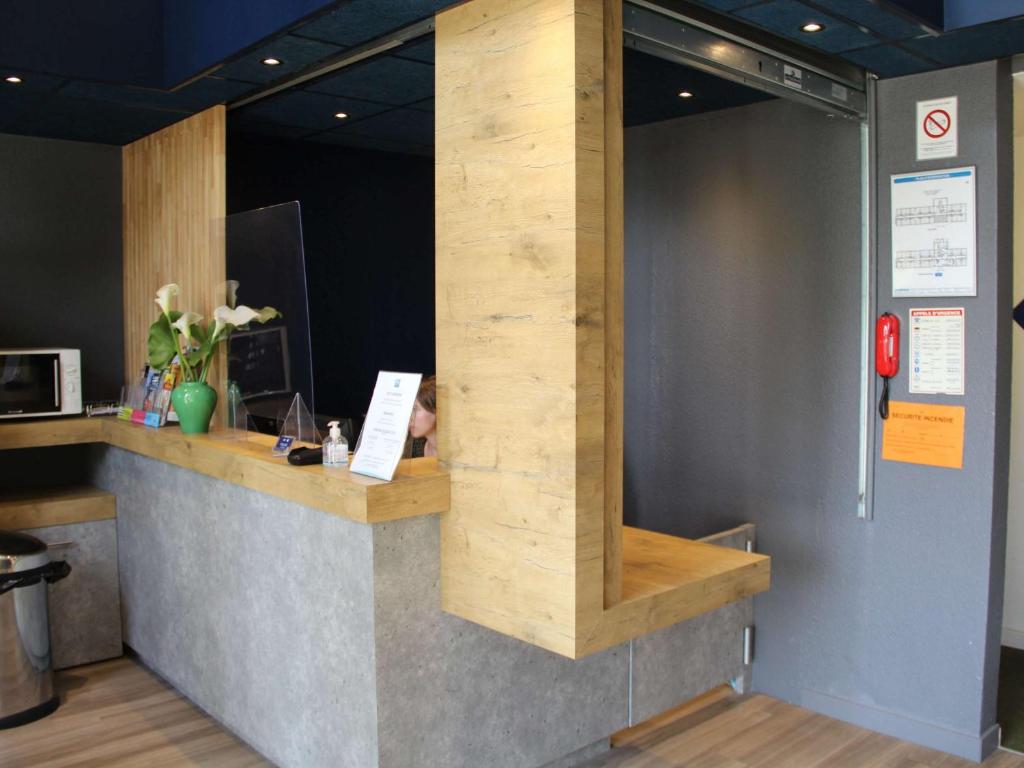 a counter in a room with a wooden wall at ibis budget Redon in Redon