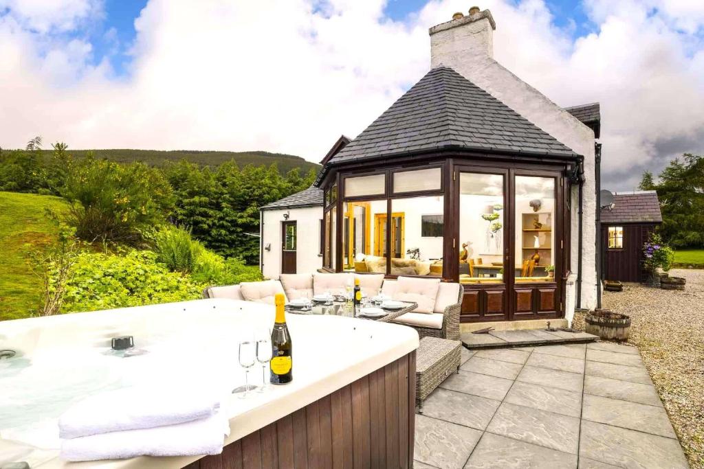 a bath tub in front of a house at Rowan Cottage in Aviemore