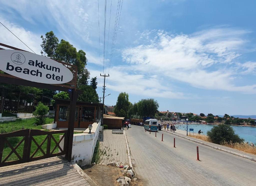 a sign on the side of a road next to a beach at Akkum Beach Otel in Seferihisar