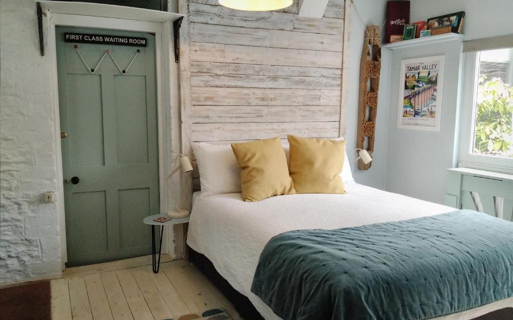 um quarto com uma cama e uma porta verde em The Artist's Retreat em Calstock