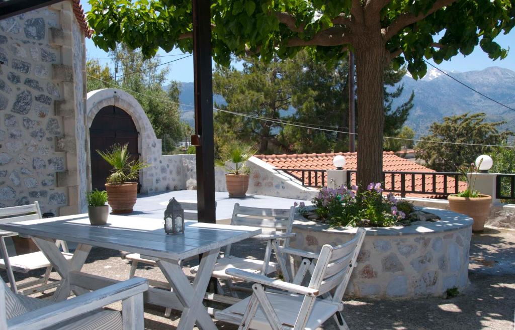 un patio con mesa, sillas y un árbol en Villa Eternity, en Alikampos