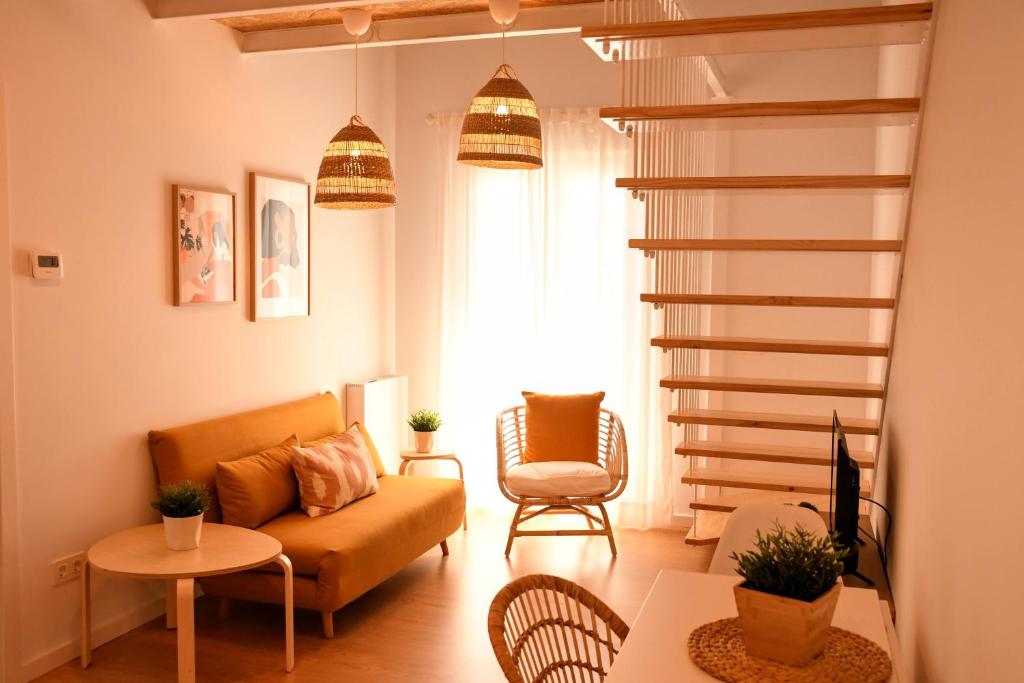 uma sala de estar com um sofá e uma cadeira em Arco da Vella apartamentos em Vilanova de Arousa
