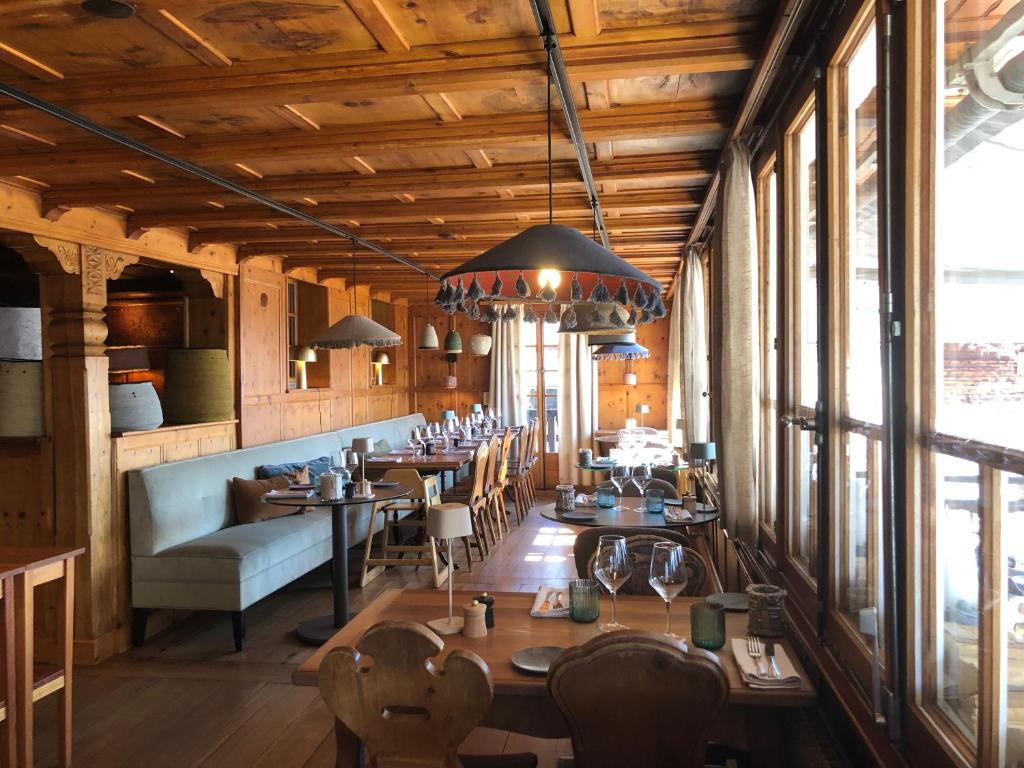 a restaurant with wooden ceilings and tables and chairs at Hôtel Le Grand Chalet Favre in Saint-Luc