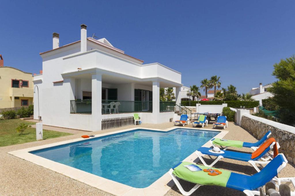 a villa with a swimming pool in front of a house at Villa Natasha by Villa Plus in Cala en Forcat