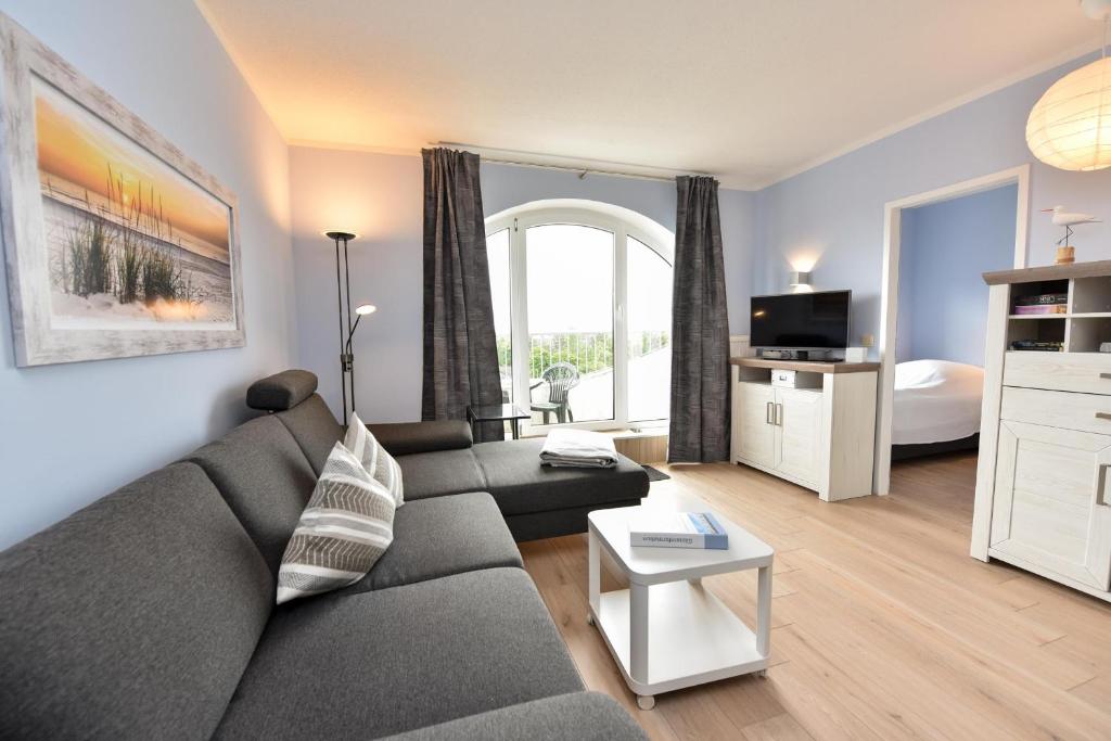 ein Wohnzimmer mit einer Couch und einem Bett in der Unterkunft "Appartementhaus Deichgraf" Appartement D450 in Döse