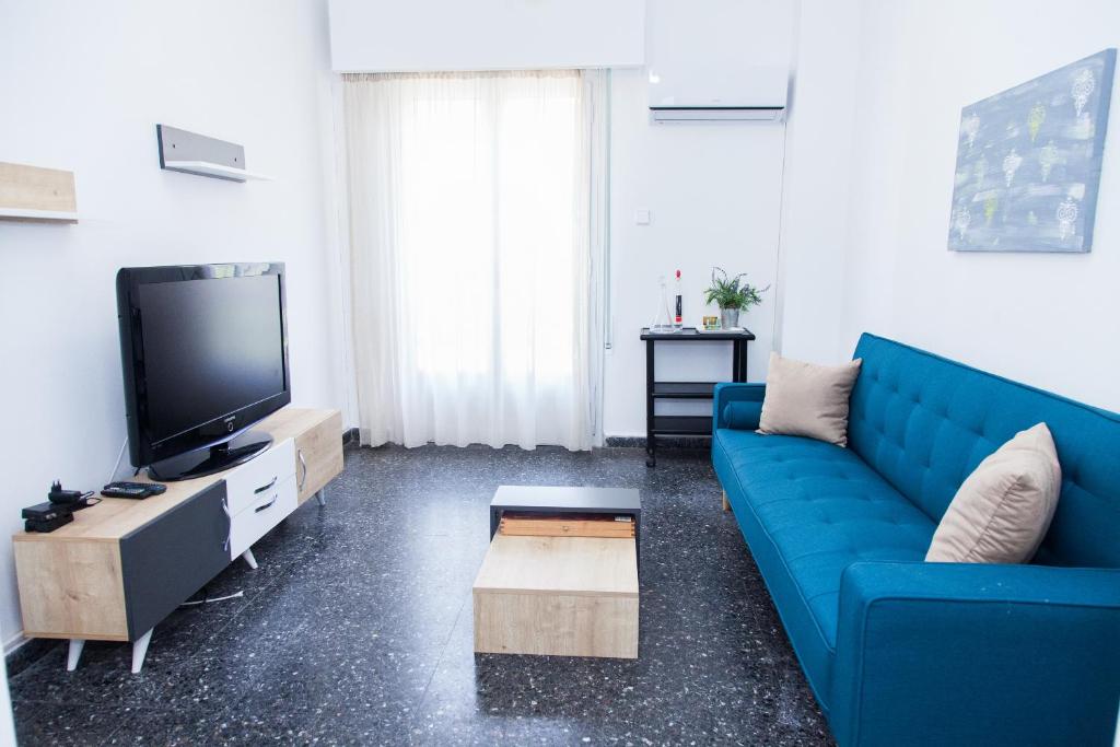 a living room with a blue couch and a tv at Beautifull Apartment in Piraeus in Piraeus