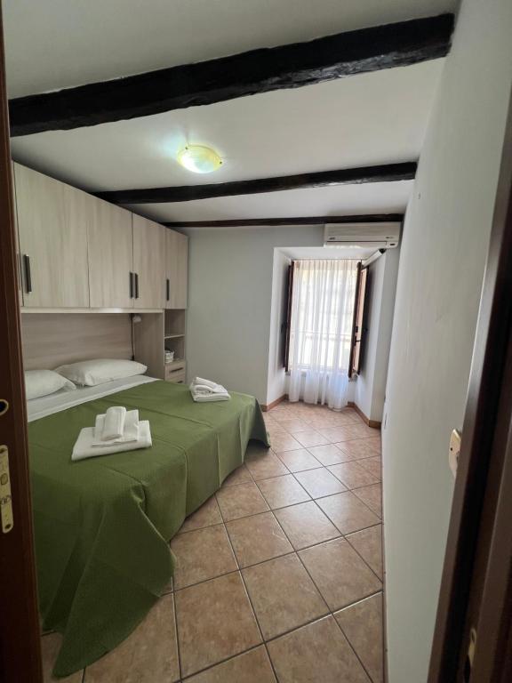 a room with a green bed and a window at Casa Ambrosia Tropea in Tropea