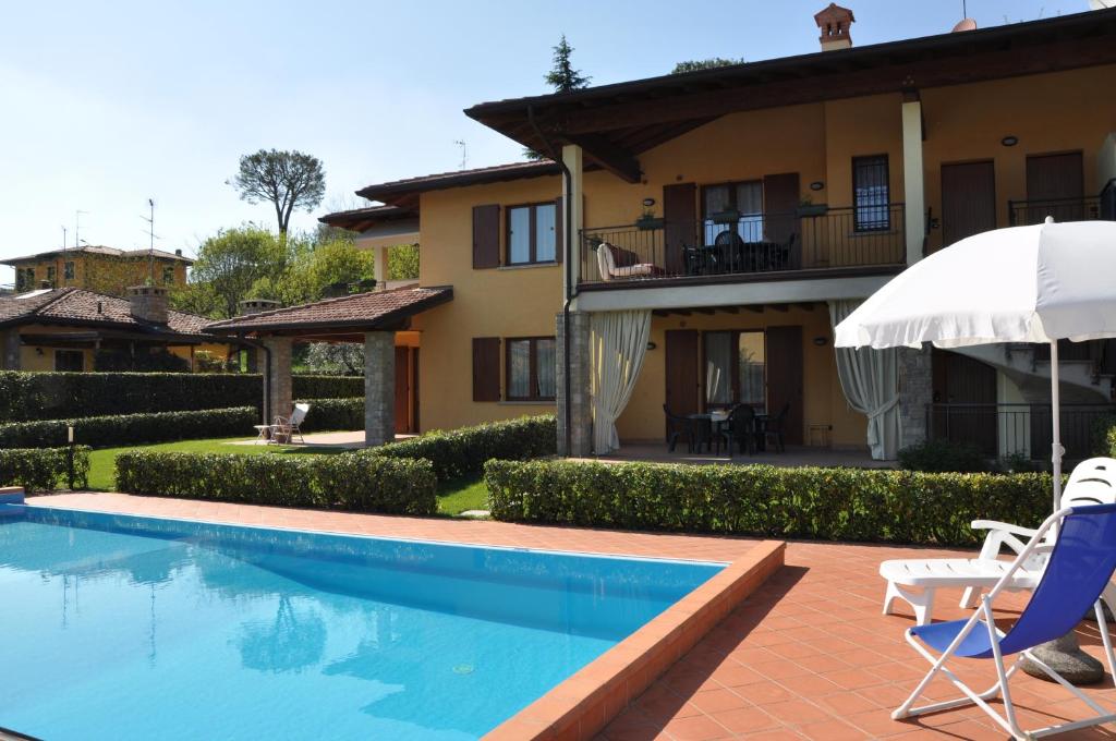 a villa with a swimming pool and a house at Apartments I Ciclamini in Moniga