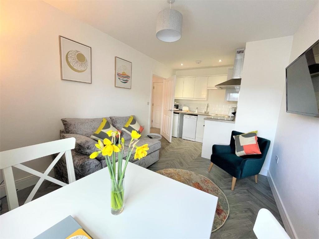 a living room with a vase of flowers on a table at Modern 2 Bed Apt Centre Of Penzance, Lift Access in Penzance