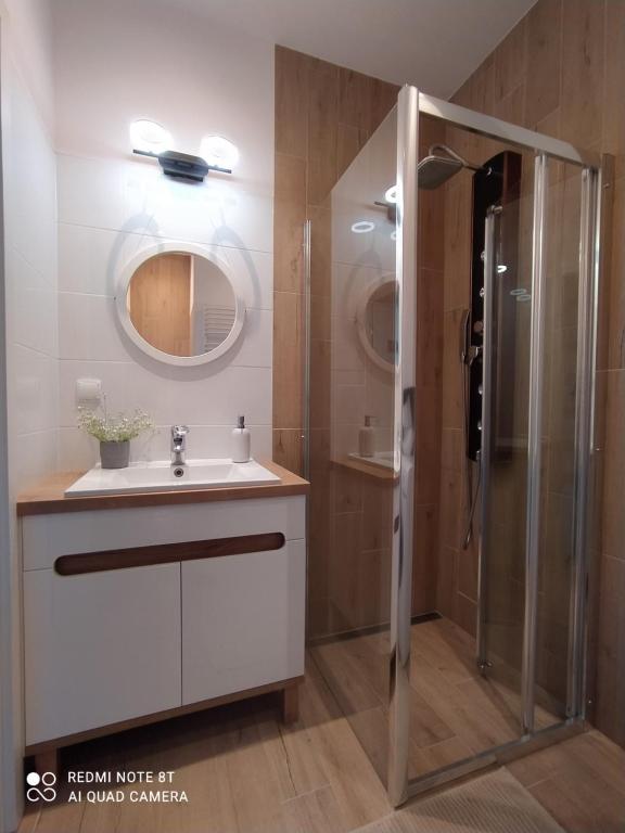 a bathroom with a sink and a shower at Apartament blisko dwóch jezior na Warmii i Mazurach in Biskupiec