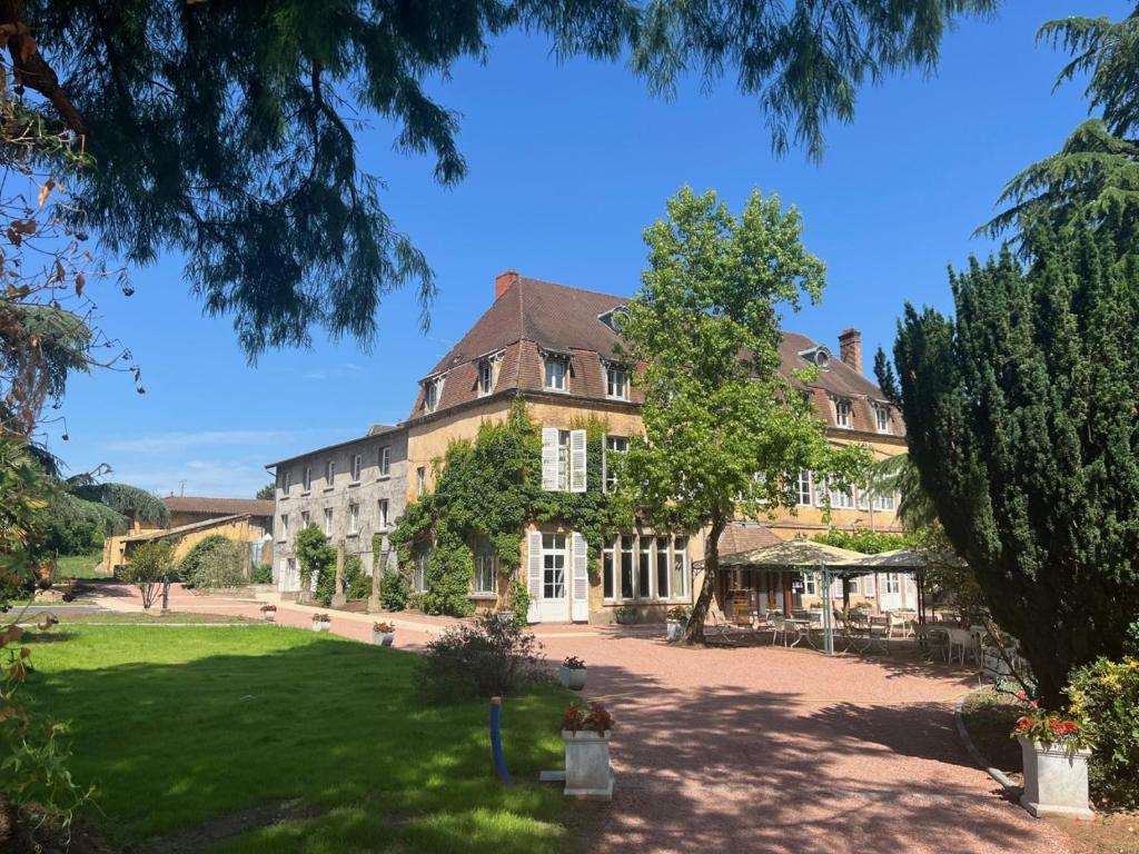 una casa grande con un gran patio delante en Château de La Barge, en Chaintré