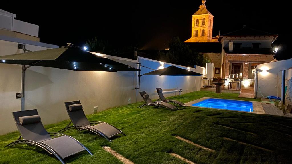 a yard with chairs and a swimming pool at night at LA ANTIGUA TABERNA in Nieva
