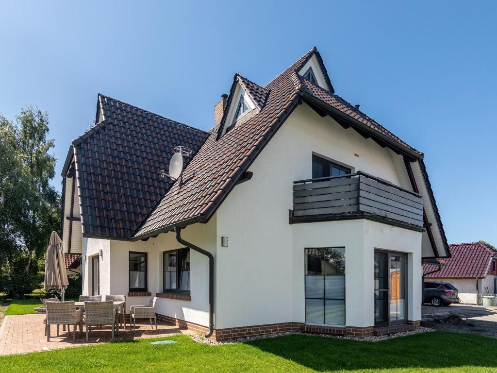 ein weißes Haus mit schwarzem Dach in der Unterkunft Ferienwohnungen Haus am Strand in Zingst