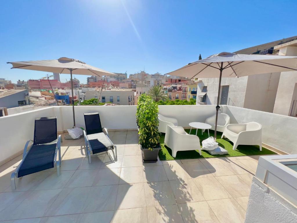 アリカンテにあるCasa Toledo & El Pont Alicante Apartmentsのバルコニー(屋上の椅子、テーブル、パラソル付)