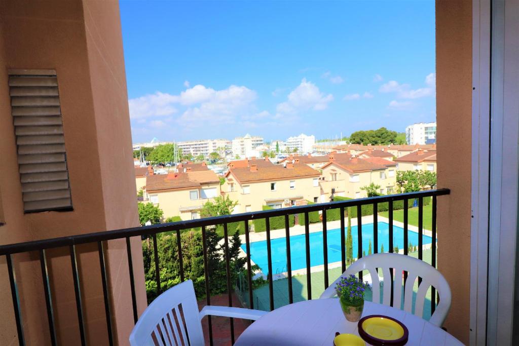 een balkon met een tafel en stoelen en een zwembad bij Mediterraneo 2 3 6 Roses - Immo Barneda in Roses