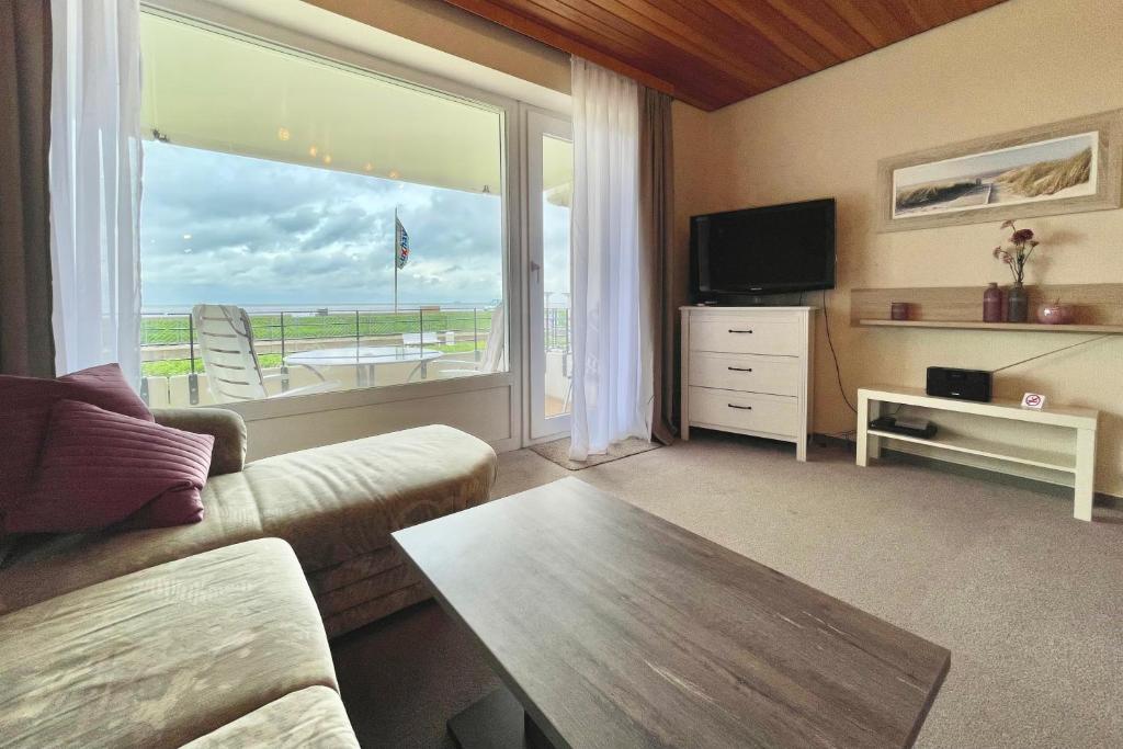 - un salon avec un canapé et une grande fenêtre dans l'établissement Haus "Nautilus" Appartement NAU004, à Cuxhaven