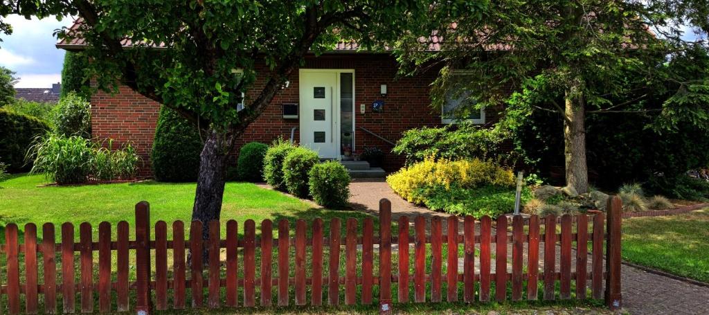 a red fence in front of a house at Mühlberg, Ferienwohnung in Schneverdingen