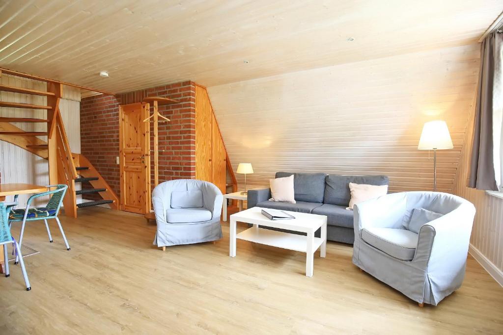 a living room with a couch and chairs and a table at An der Steilküste Finnhütte 01 in Boltenhagen