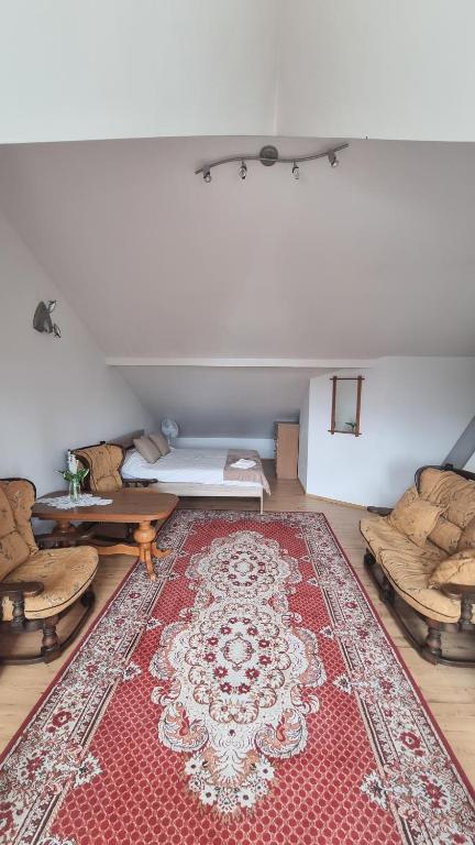 sala de estar con alfombra roja en el suelo en Apartment na poddaszu, en Augustów
