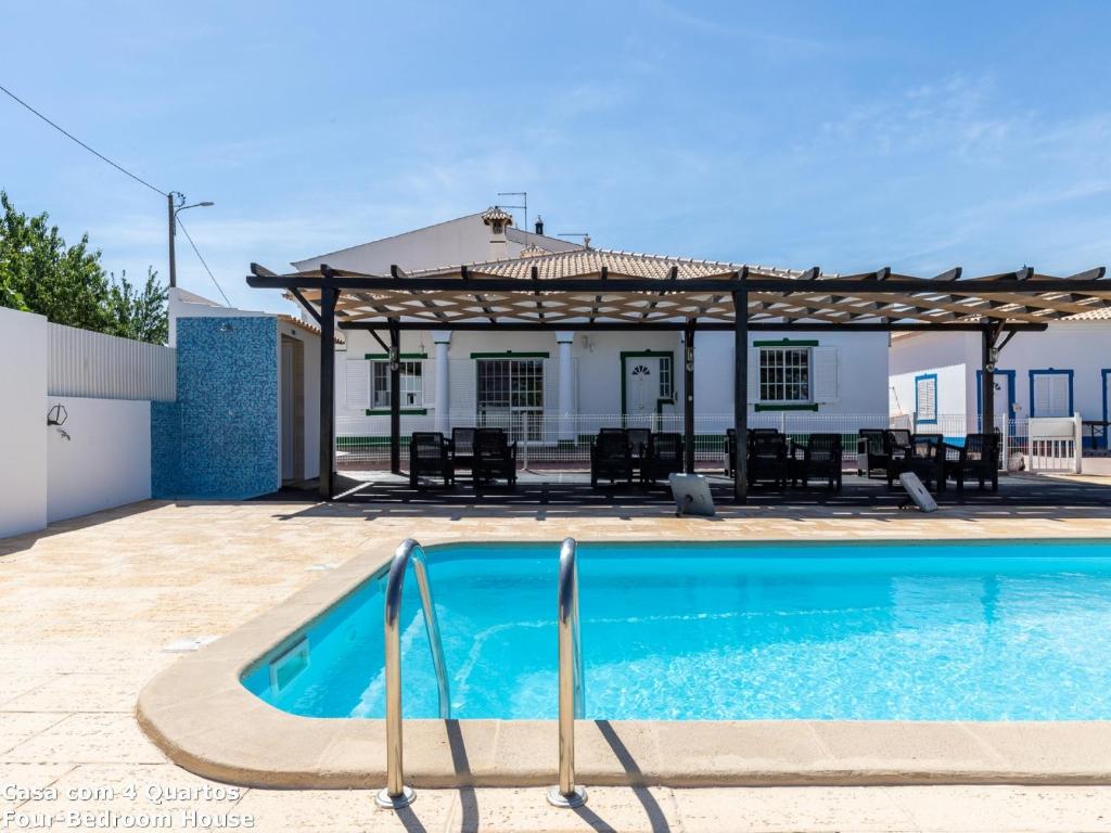 a swimming pool in front of a house with a gazebo at Akisol Albufeira Sun in Albufeira