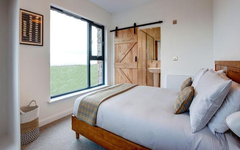 a bedroom with a bed and a large window at 5 Bedroom Cottage - Llyn Peninsula in Pistyll
