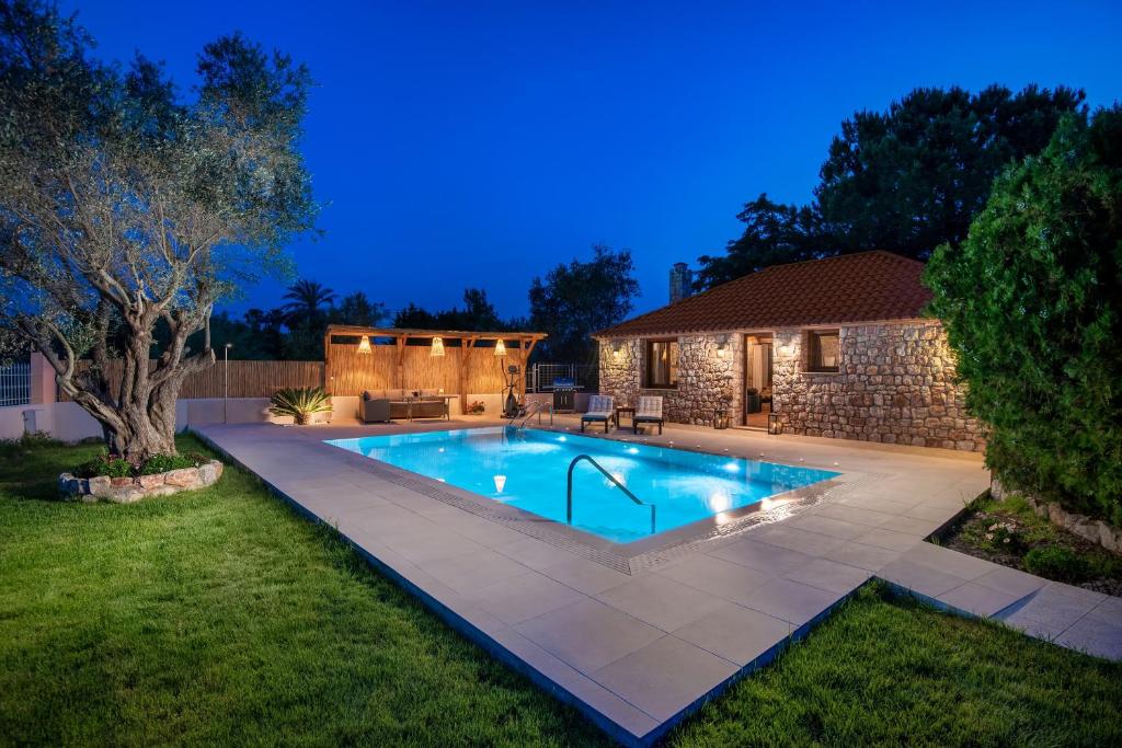 una piscina en un patio por la noche en Filerolia Stone House, en Pastida