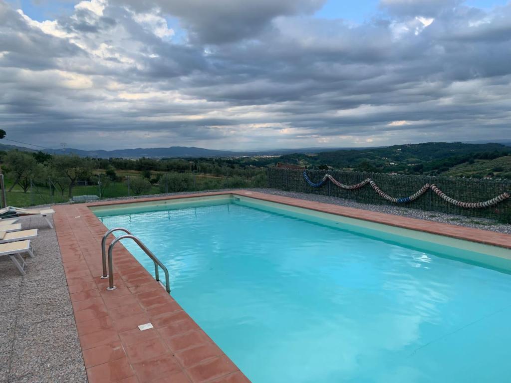 a large swimming pool with a view of the mountains at Casa Musa in Capannori