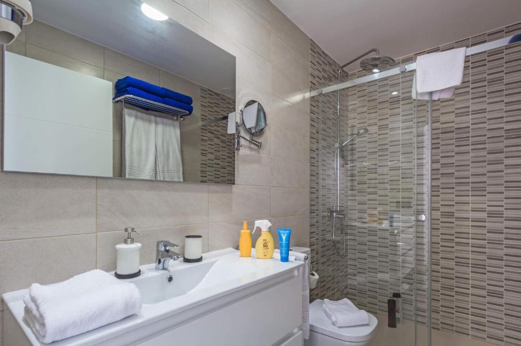 łazienka z umywalką i prysznicem z lustrem w obiekcie Villa Alana by Villa Plus w Corralejo