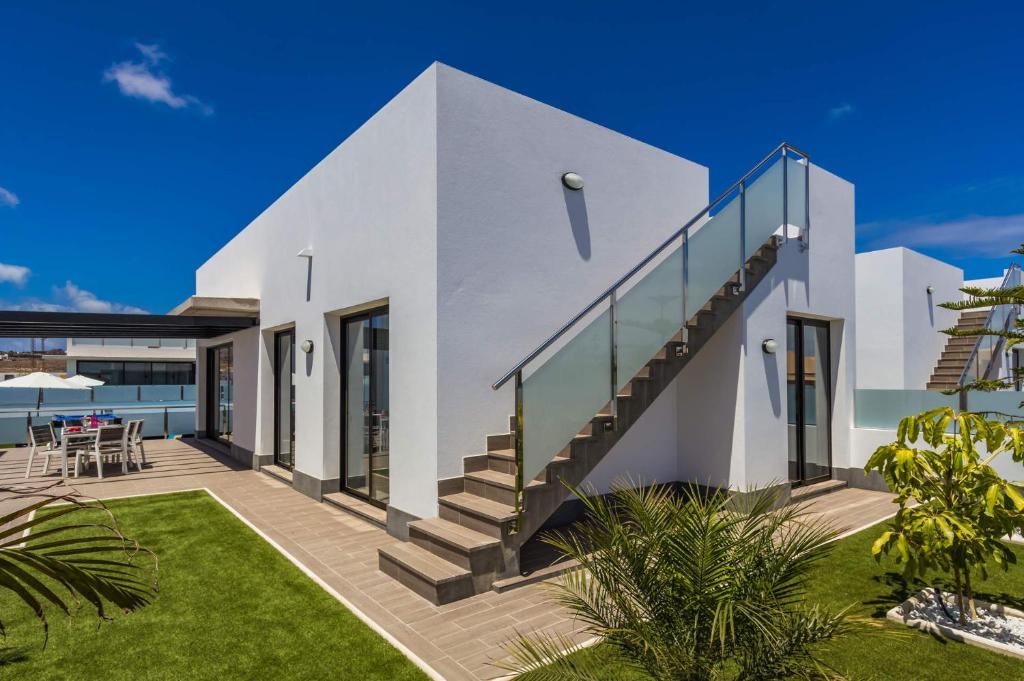 Biały dom ze schodami i patio w obiekcie Villa Alana by Villa Plus w Corralejo