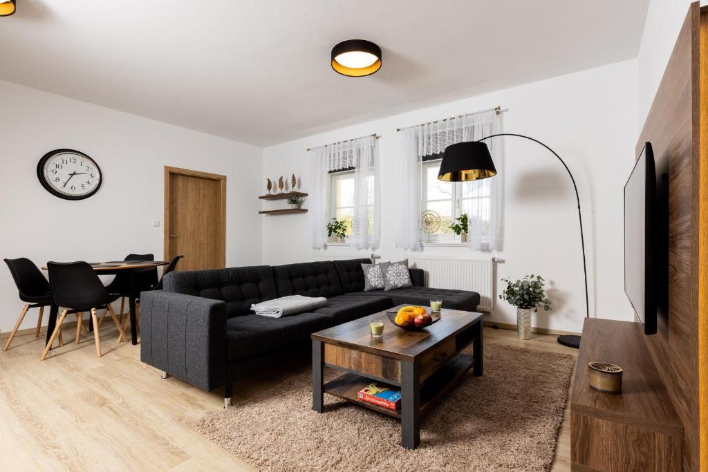sala de estar con sofá negro y mesa en Apartmán 21 Hubertus, en Karlova Studánka