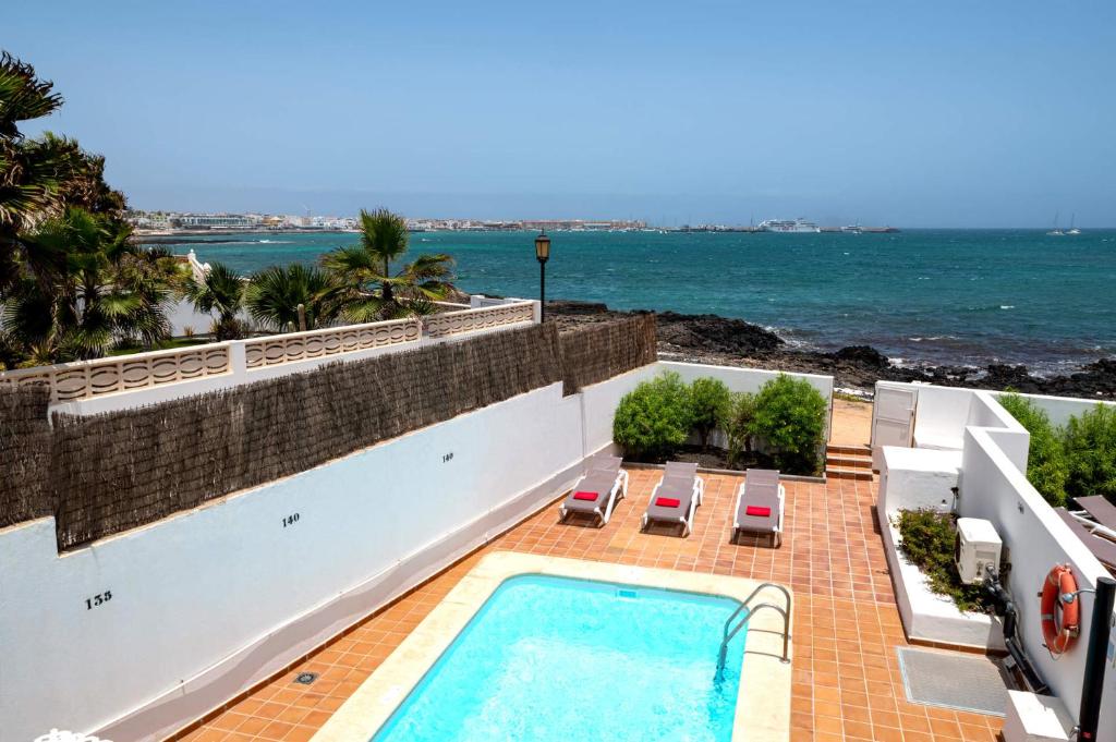 a swimming pool on top of a building next to the ocean at Villa Isabella by Villa Plus in Corralejo
