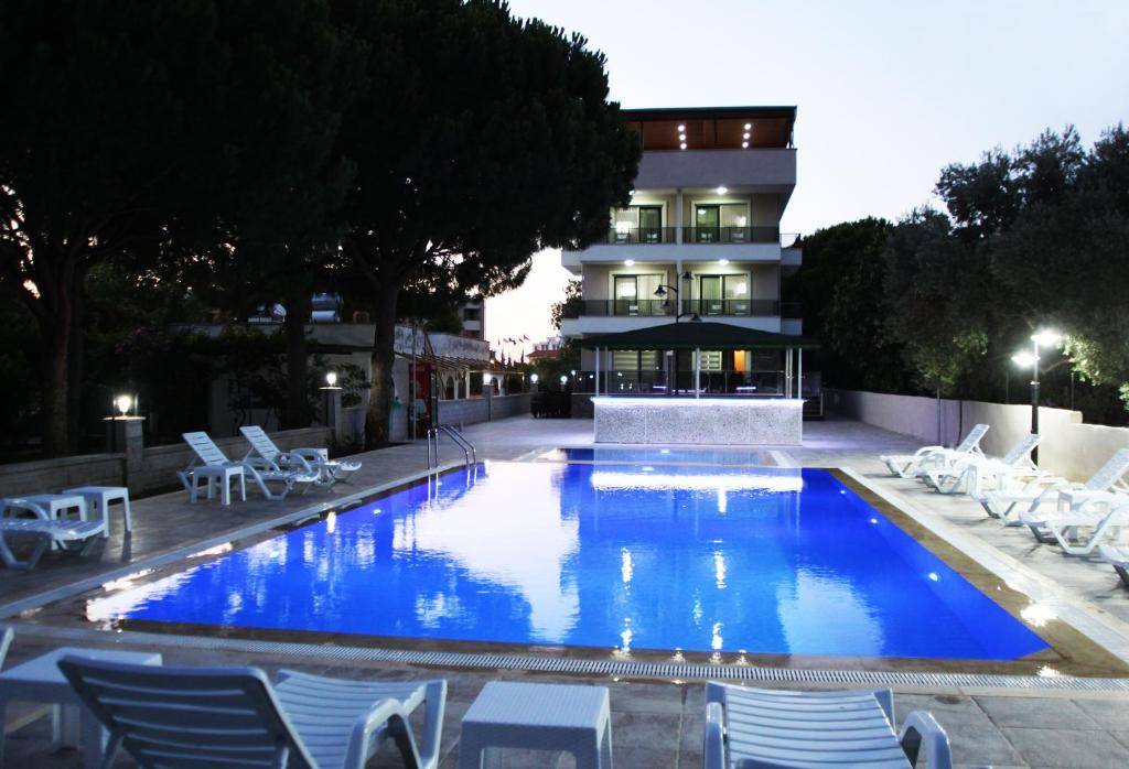 a large swimming pool with chairs and a building at Keyf Konak Boutique Hotel in Aydın