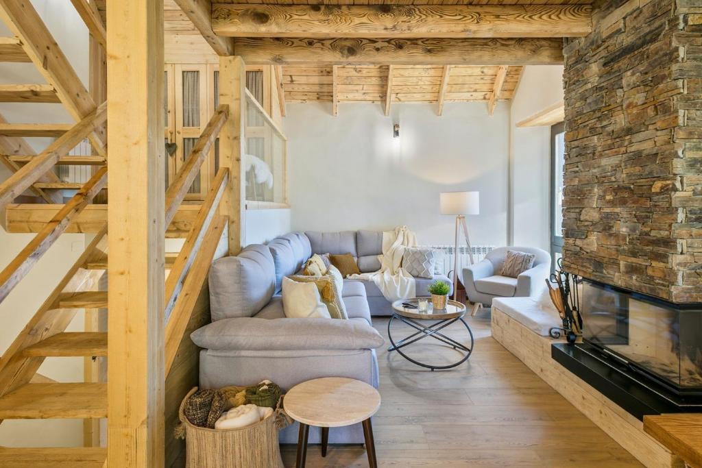 a living room with a couch and a fireplace at Luderna - Casa Montgarri in Naut Aran